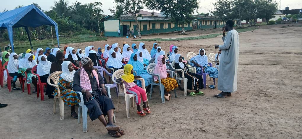 Sheikh offering guidance to youth gathered in a village